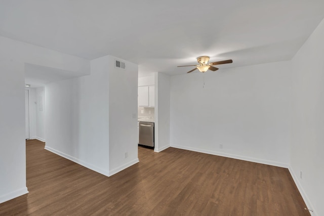 unfurnished room with dark wood finished floors, baseboards, visible vents, and a ceiling fan