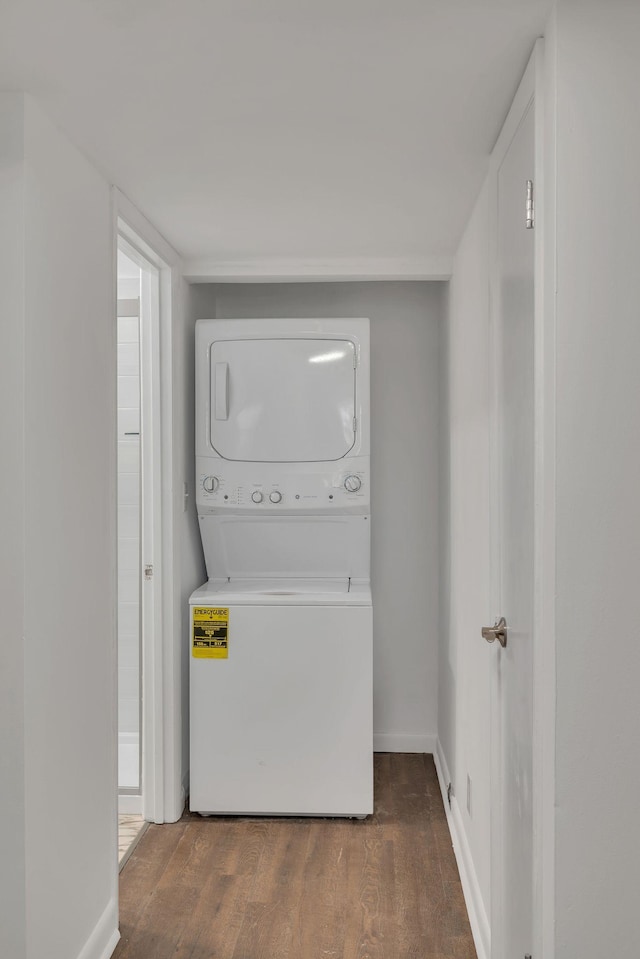 washroom with laundry area, baseboards, dark wood-style flooring, and stacked washing maching and dryer