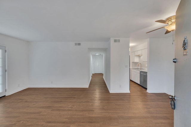 unfurnished living room featuring dark wood-style floors, visible vents, baseboards, and a sink