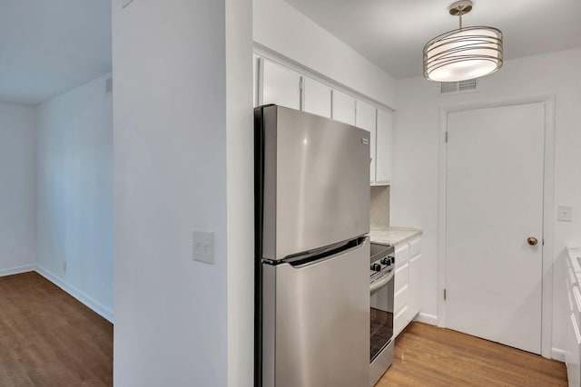 kitchen with visible vents, light wood-type flooring, light countertops, stainless steel appliances, and white cabinetry