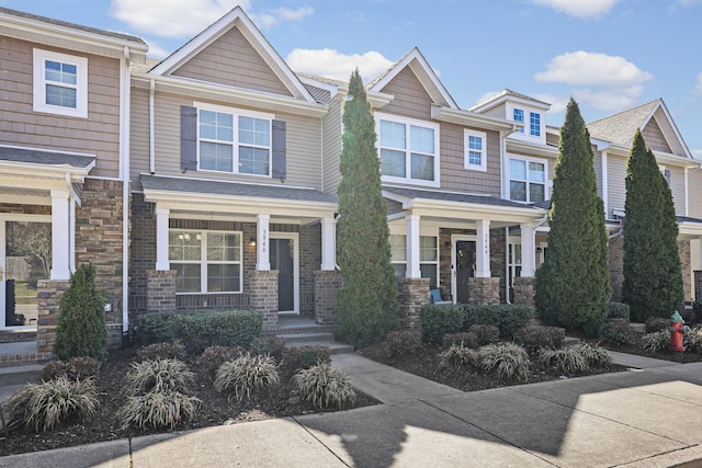 townhome / multi-family property featuring brick siding and stone siding