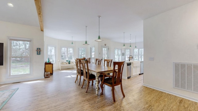 dining space with visible vents, beamed ceiling, baseboards, and light wood-style floors