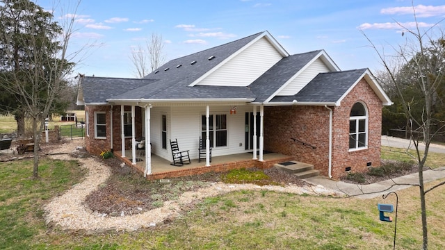 view of front of home with crawl space, brick siding, a porch, and roof with shingles