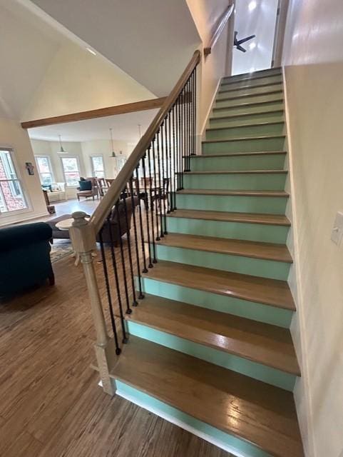 stairway with high vaulted ceiling and wood finished floors