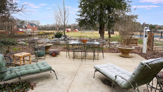 view of patio with outdoor dining space and fence