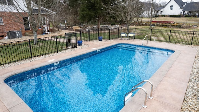 view of swimming pool featuring a fenced in pool, fence, central AC unit, a yard, and a patio area