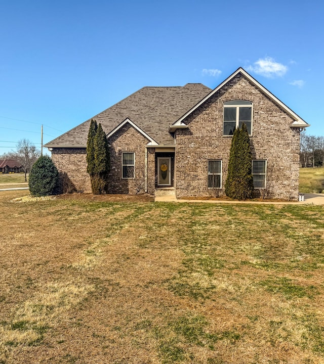 view of front of property with brick siding and a front lawn