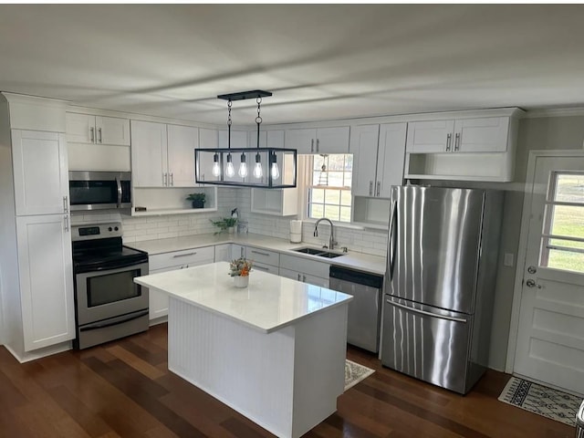 kitchen featuring a sink, backsplash, light countertops, appliances with stainless steel finishes, and dark wood-style flooring