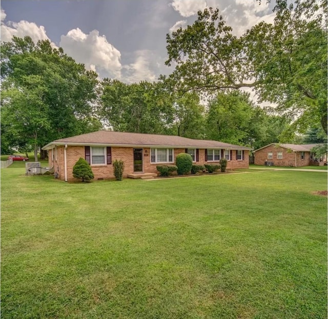 single story home featuring brick siding and a front lawn