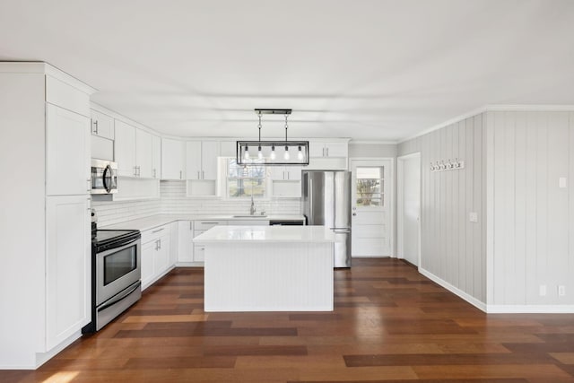 kitchen with a kitchen island, dark wood-style flooring, a sink, stainless steel appliances, and light countertops