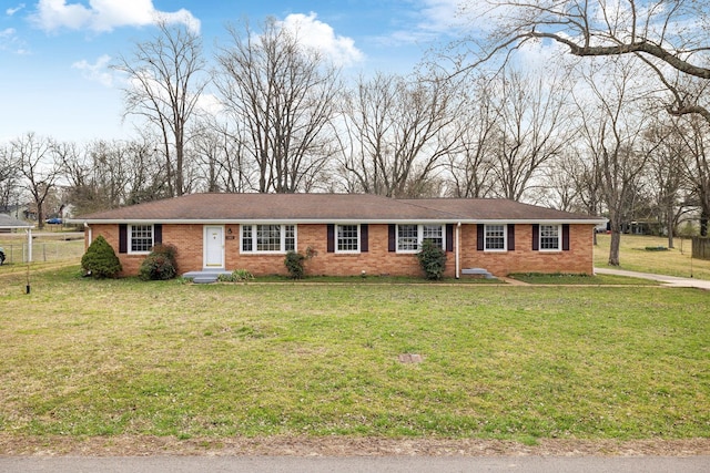 ranch-style home featuring brick siding, a front yard, and fence