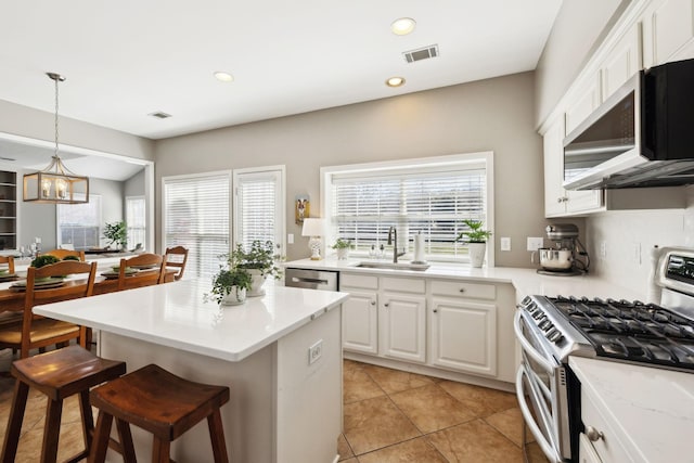 kitchen with visible vents, a breakfast bar, plenty of natural light, stainless steel appliances, and a sink