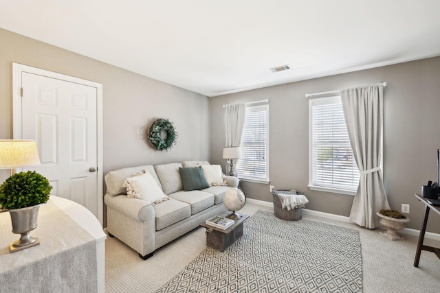 living room featuring light carpet, visible vents, and baseboards