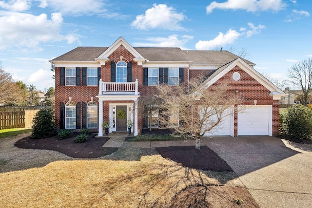 colonial-style house with brick siding, concrete driveway, and fence