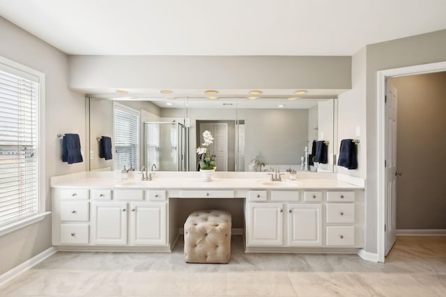 bathroom with a sink, double vanity, and a shower stall