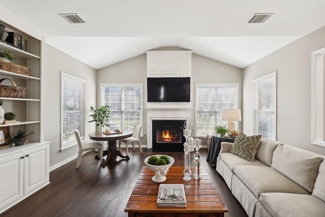 living room with vaulted ceiling, visible vents, a fireplace, and dark wood-style flooring