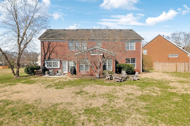 rear view of property featuring a patio, a yard, fence, and a fire pit