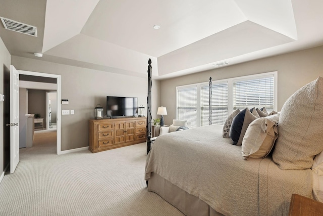 bedroom featuring a tray ceiling, visible vents, light carpet, and baseboards