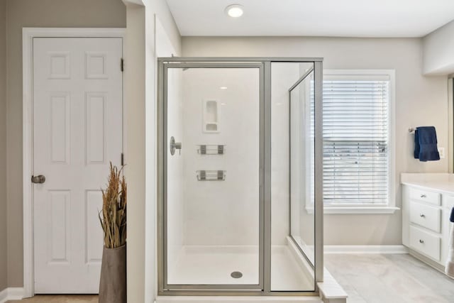 bathroom featuring baseboards, vanity, marble finish floor, and a shower stall