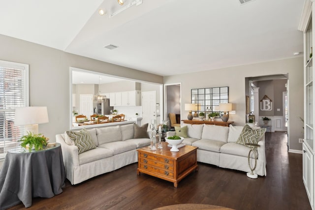 living area with visible vents and dark wood-style floors