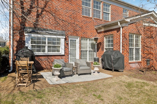 rear view of property featuring brick siding and a patio area