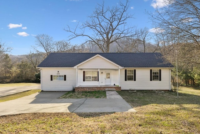 view of front of house with covered porch, roof with shingles, concrete driveway, and a front lawn