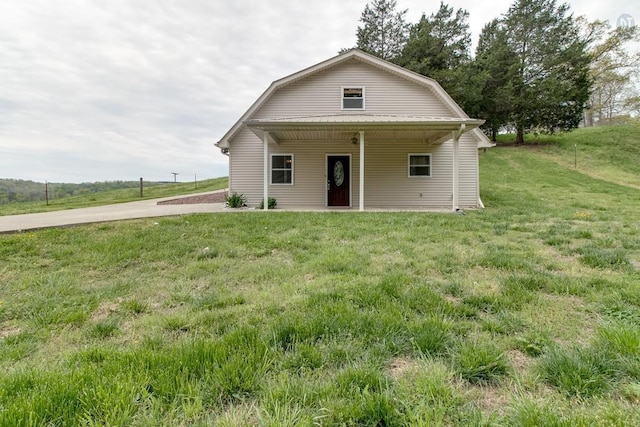 back of house with a lawn and a gambrel roof