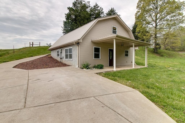 view of front of home featuring metal roof, a gambrel roof, a front lawn, and a patio area