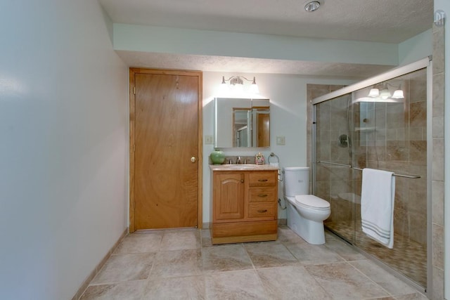 full bathroom with toilet, a textured ceiling, a shower stall, baseboards, and vanity