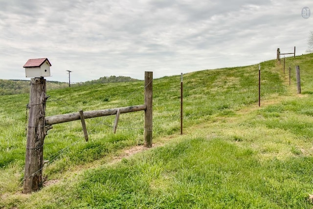 view of yard featuring a rural view and fence