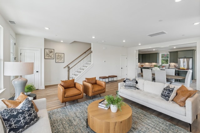 living area with visible vents, recessed lighting, stairway, and light wood-style floors