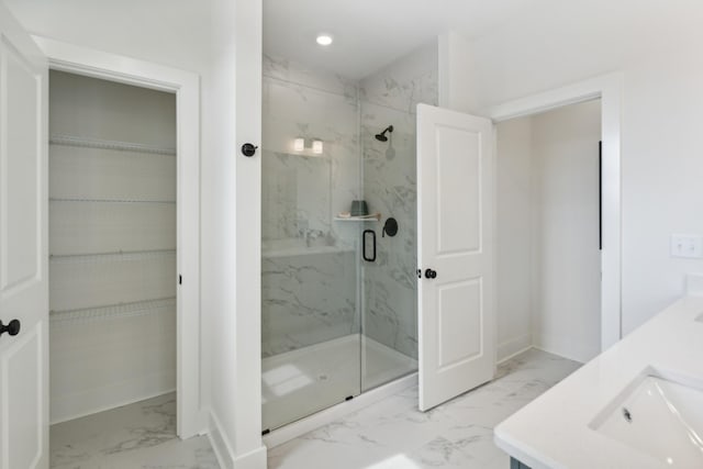 full bathroom featuring a spacious closet, marble finish floor, and a marble finish shower