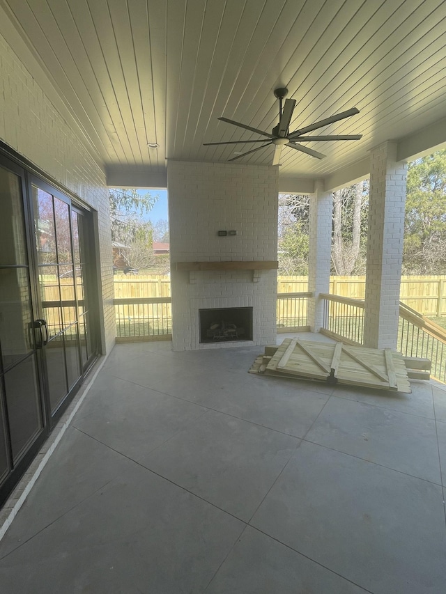 view of patio / terrace with fence, an outdoor brick fireplace, and ceiling fan