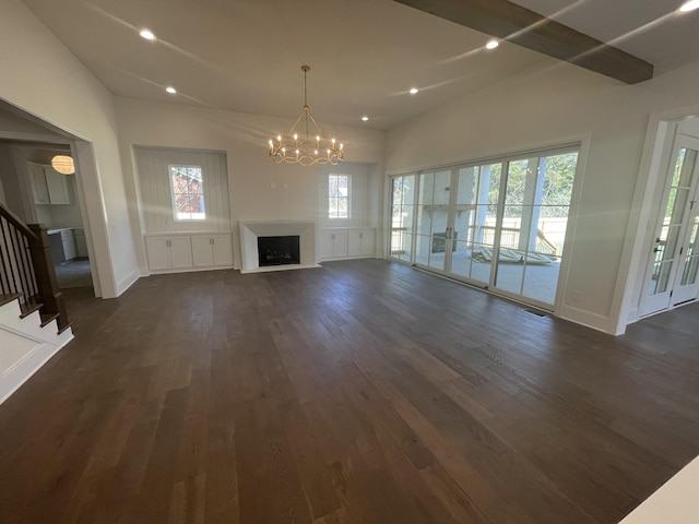 unfurnished living room with stairway, dark wood-style floors, an inviting chandelier, recessed lighting, and a fireplace with raised hearth