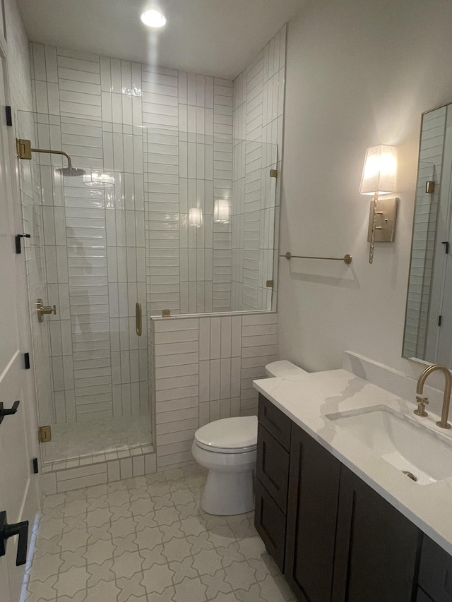 full bathroom with toilet, a stall shower, and vanity