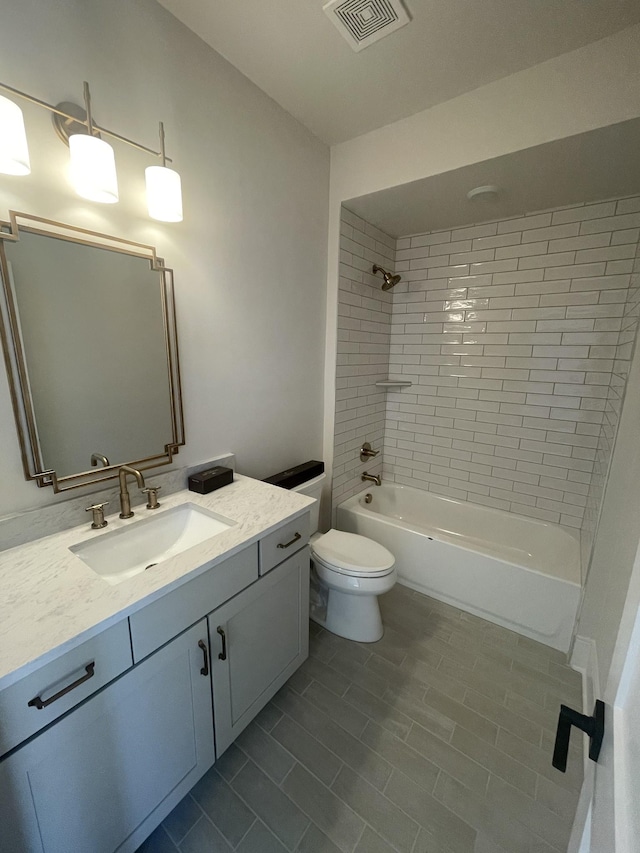 bathroom with vanity, toilet, tub / shower combination, and visible vents