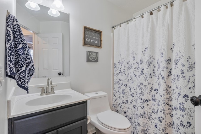 bathroom with vanity, curtained shower, and toilet