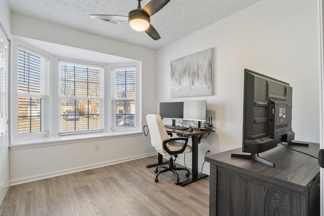 home office featuring ceiling fan, baseboards, a textured ceiling, and wood finished floors