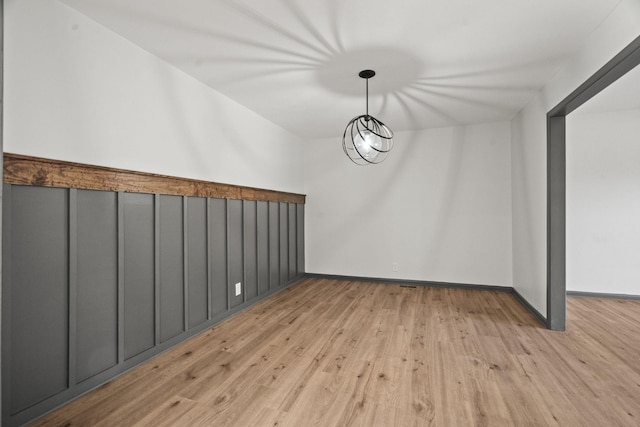 unfurnished dining area with baseboards and light wood-type flooring