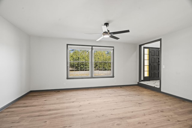 spare room featuring a ceiling fan, wood finished floors, and baseboards