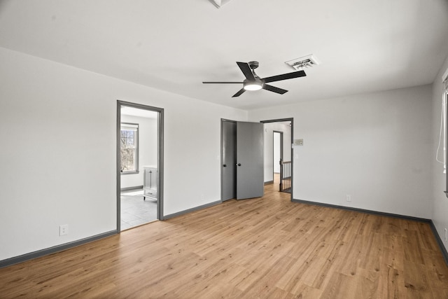 unfurnished bedroom featuring visible vents, a ceiling fan, connected bathroom, light wood finished floors, and baseboards