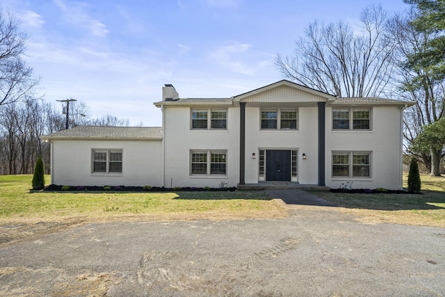 view of front of house featuring a front lawn and a chimney