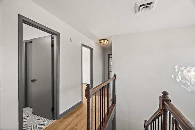 stairs featuring visible vents, baseboards, and wood finished floors