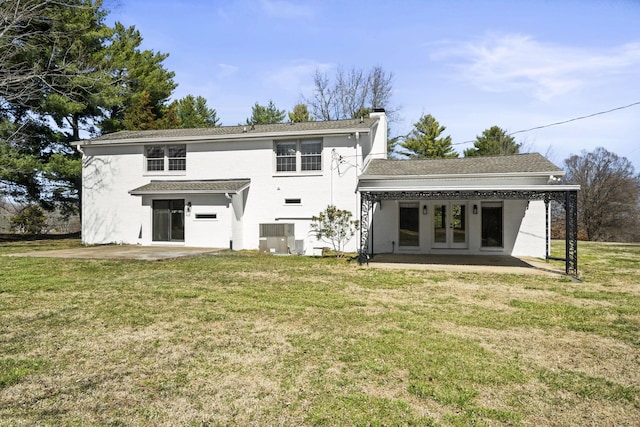 rear view of house with a patio area, french doors, and a lawn