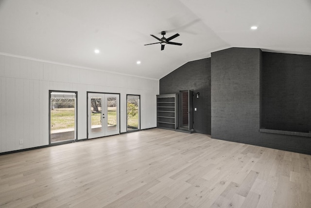 unfurnished living room featuring a ceiling fan, vaulted ceiling, wood finished floors, and french doors