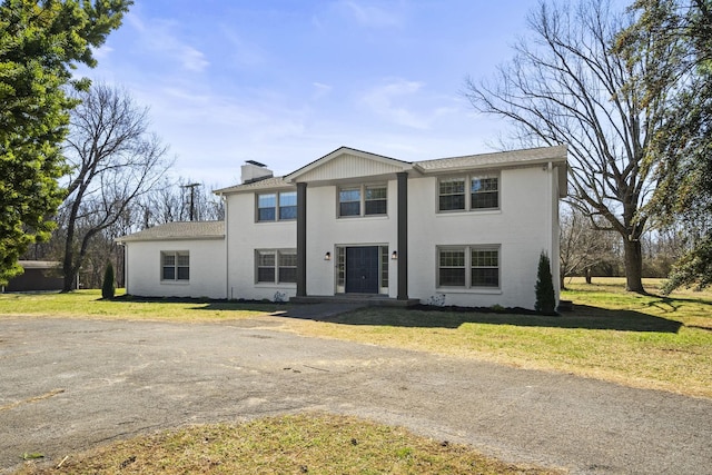 view of front of house with a chimney and a front lawn