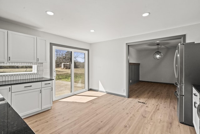 kitchen with light wood finished floors, baseboards, recessed lighting, freestanding refrigerator, and white cabinetry