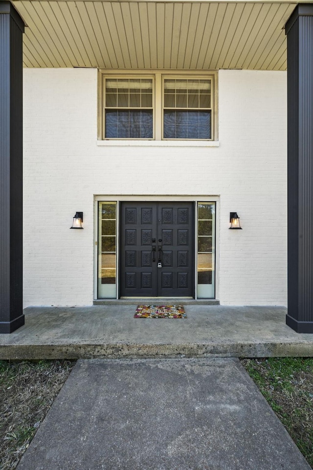 entrance to property featuring brick siding