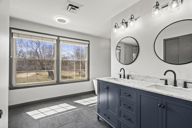 full bath featuring double vanity, visible vents, baseboards, and a sink