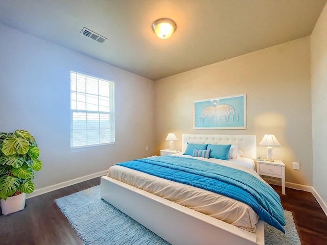 bedroom featuring dark wood-type flooring, baseboards, and visible vents